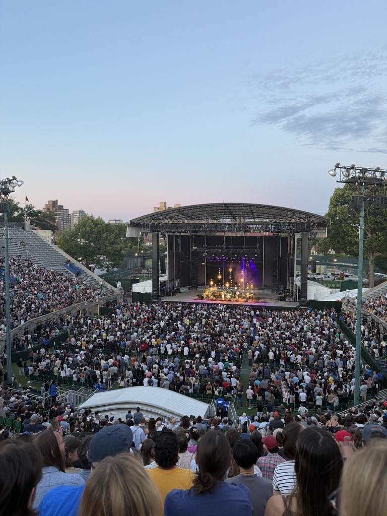 A crowd at an outdoor concert at dusk